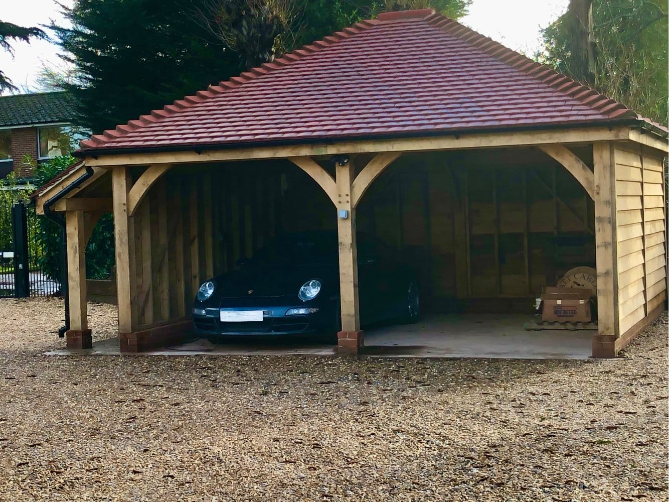A bespoke double oak car port with gravel driveway
