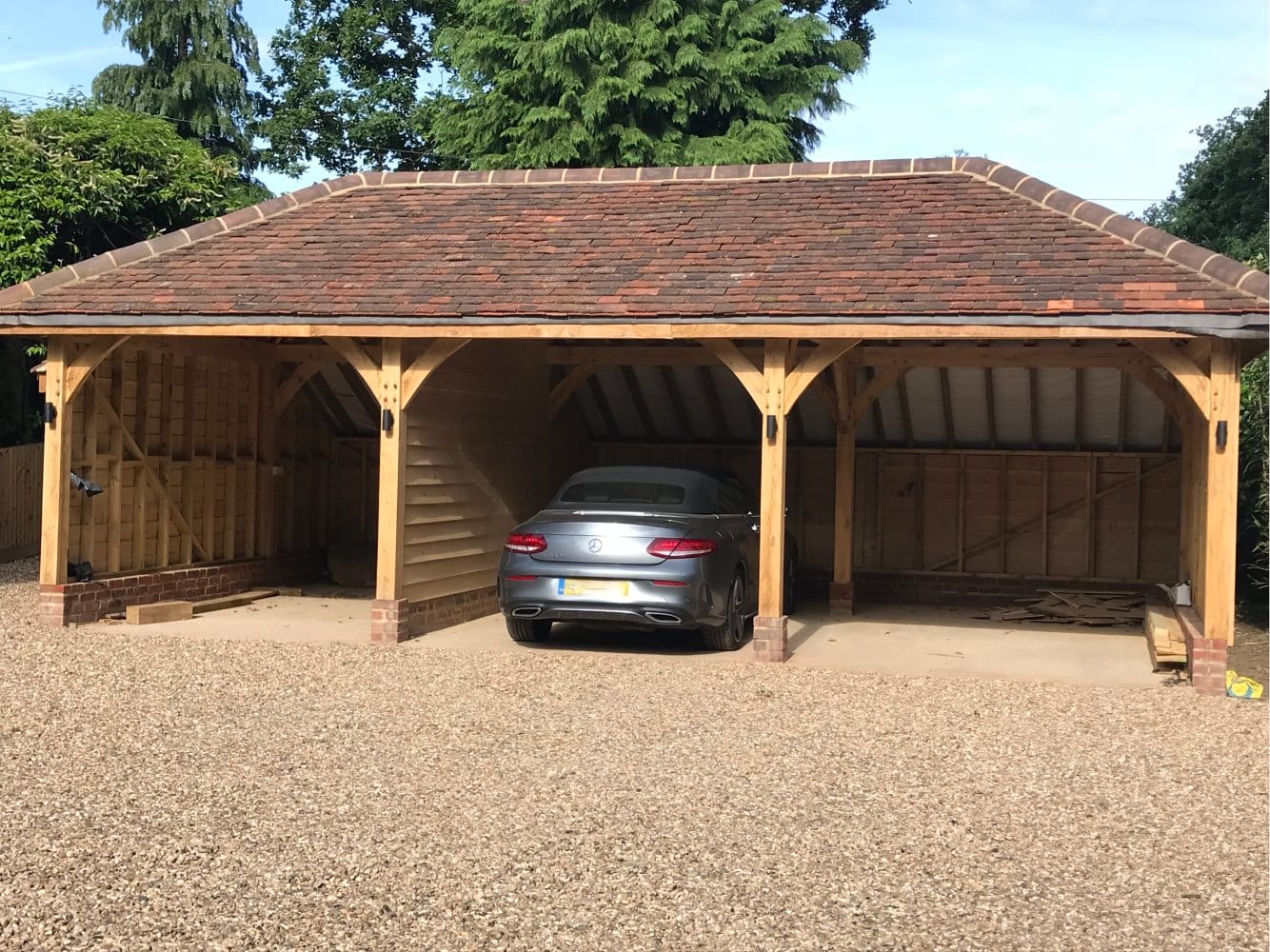 A bespoke triple oak car port and sweeping gravel drive