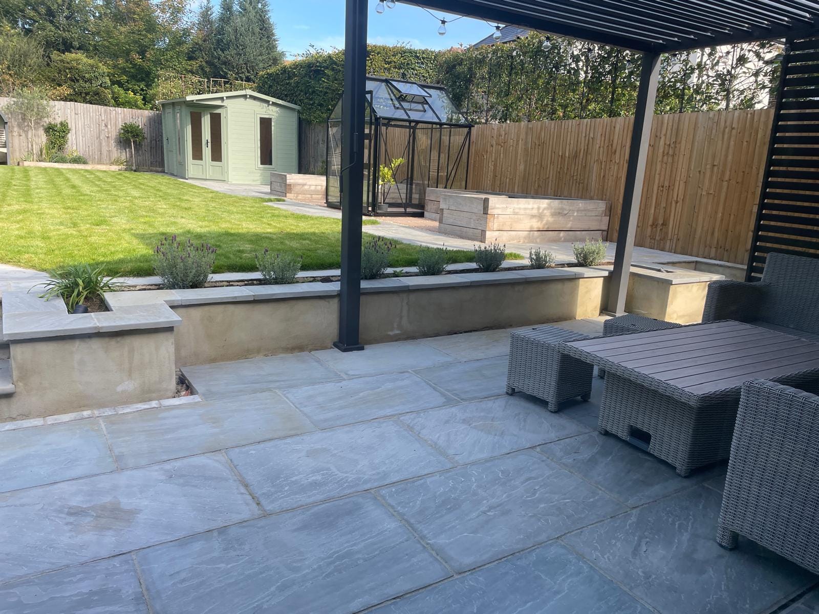Sandstone paving with louvered roof pergola